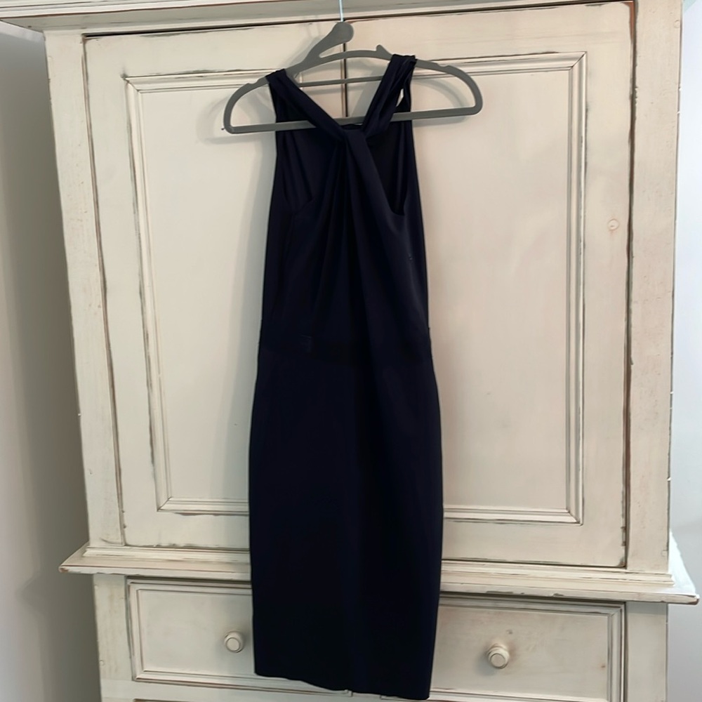 Black stretch fabric. Grosgrain waist detail. Halter neck mid knee.